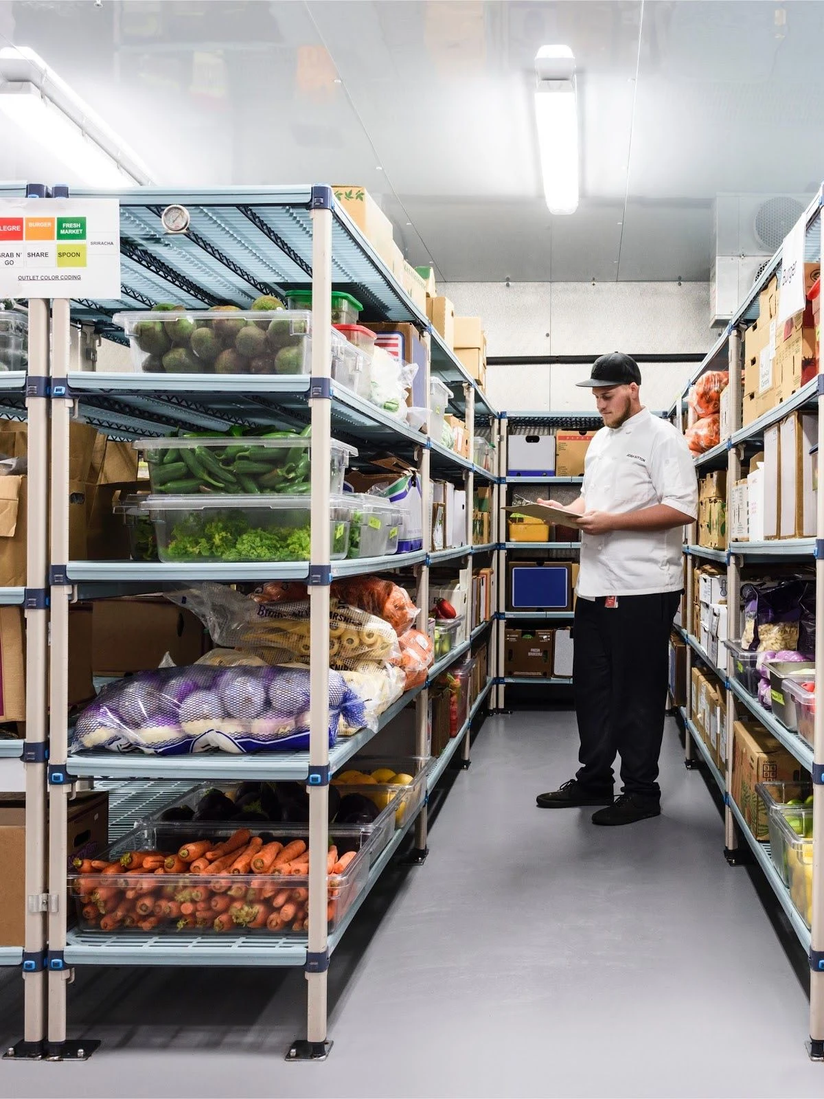 Chef reviewing inventory in a food storage cooler